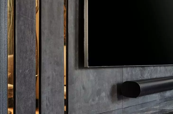 The TV wall was upholstered with black leather panels