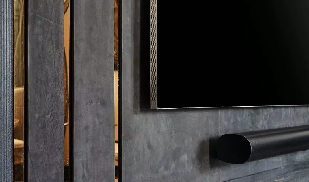 Ściana z TV została obita panelami z czarnej skóry
