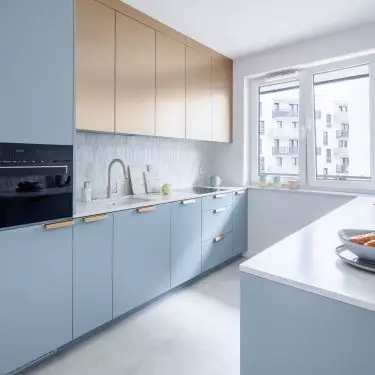 The kitchen cabinets relate in color to the living room