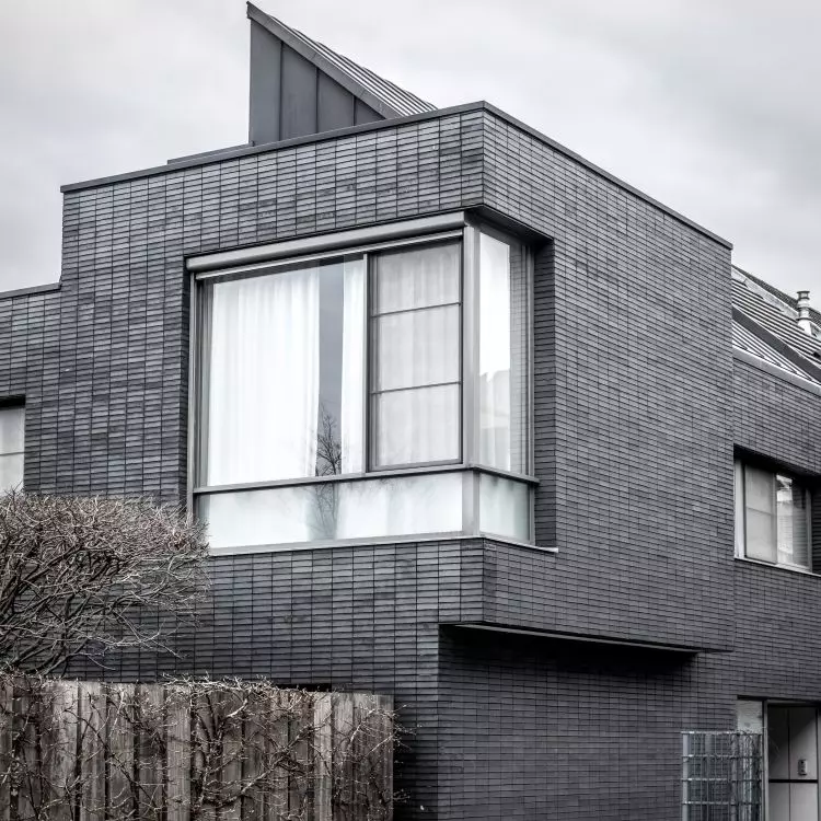 When designing the facade of a modern building, it is worth choosing tiles with a smooth surface in a shade from the palette of cool grays