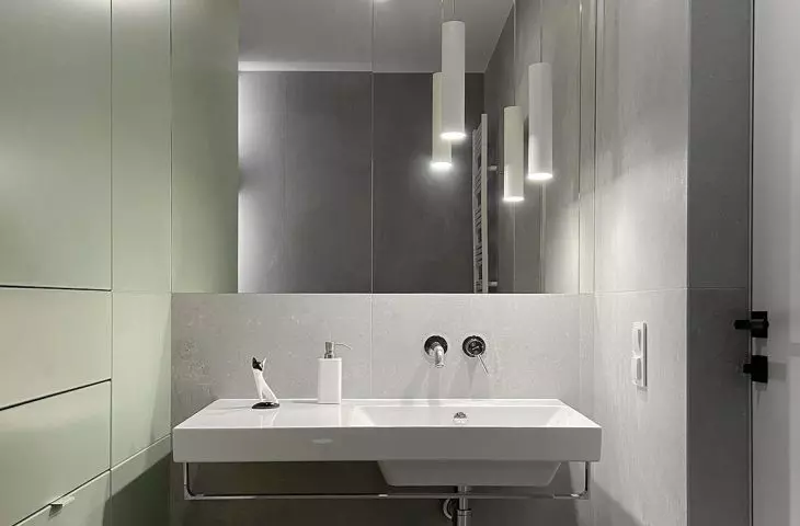 A small bathroom appears more spacious through the use of large mirrors