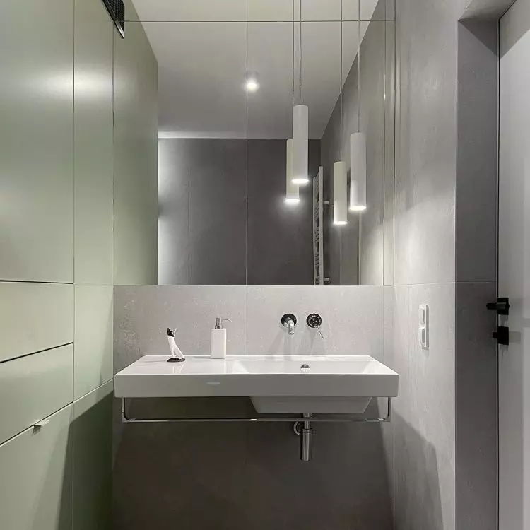 A small bathroom appears more spacious through the use of large mirrors
