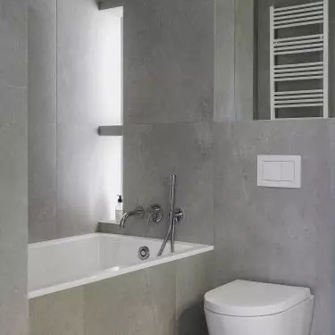 On the wall behind the bath is an illuminated bookcase