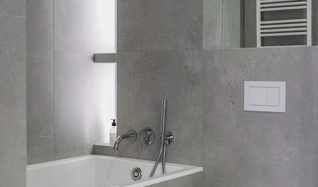 On the wall behind the bath is an illuminated bookcase
