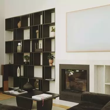 Black bookcase stands out against white wall