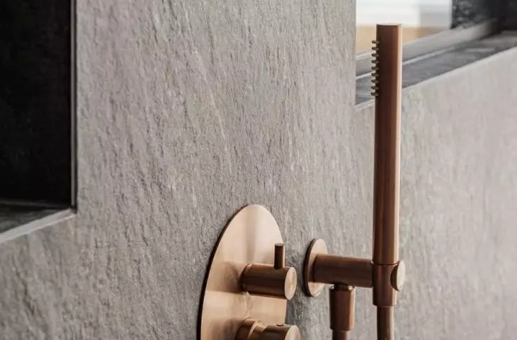 The shower area has been tiled with matte anthracite stoneware with a distinct texture