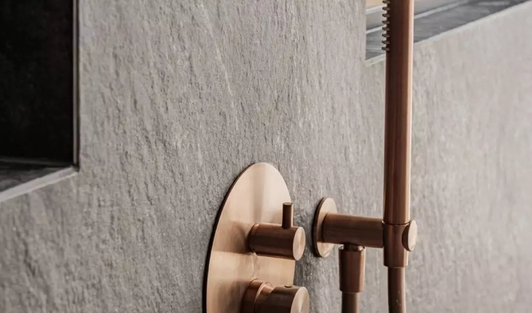 The shower area has been tiled with matte anthracite stoneware with a distinct texture