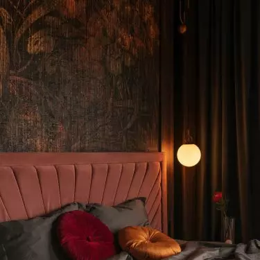 Bed in shade of dirty pink conquers warm tones of wallpaper