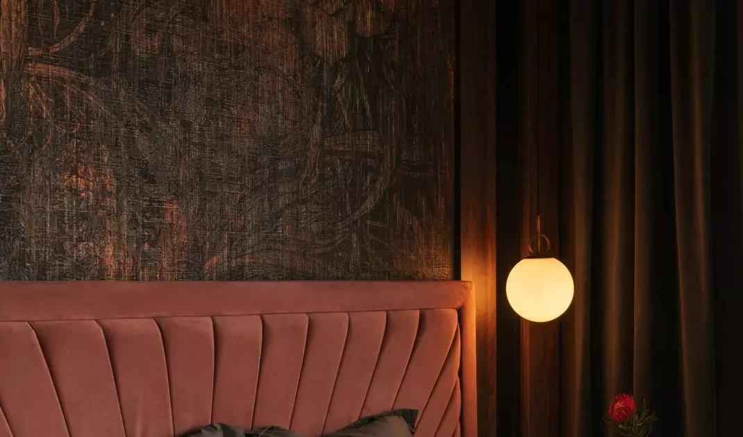 Bed in shade of dirty pink conquers warm tones of wallpaper