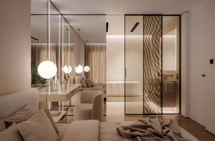 A wall of glass separates the bathroom from the bedroom