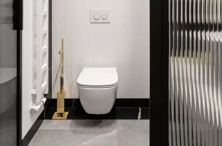 Above the toilet is a white fluted wall with built-ins