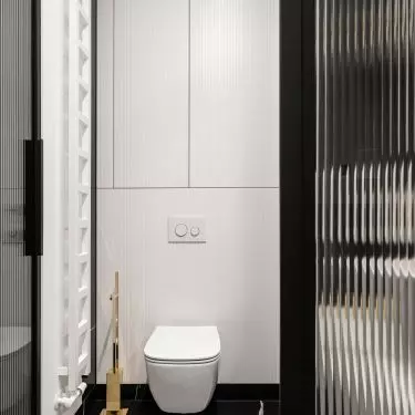 Above the toilet is a white fluted wall with built-ins