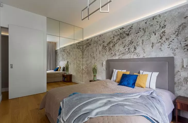 The wall behind the bed was decorated with floral wallpaper