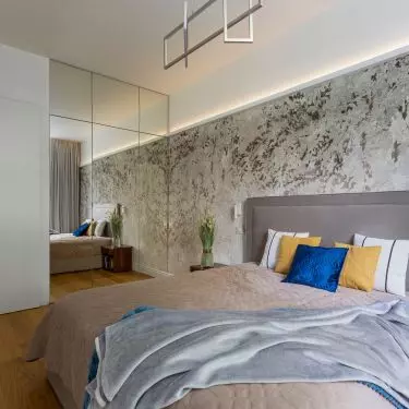 The wall behind the bed was decorated with floral wallpaper