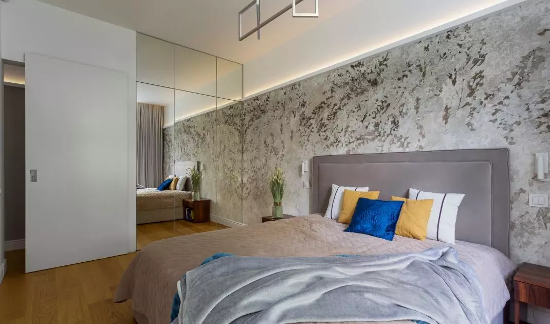 The wall behind the bed was decorated with floral wallpaper