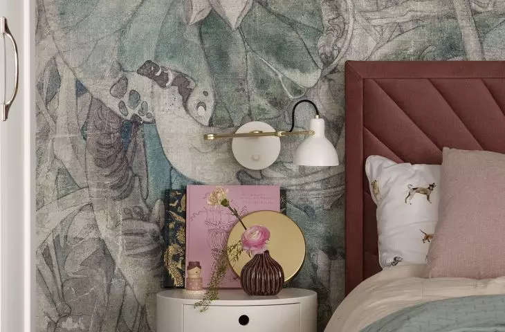 The wall behind the bed is decorated with wallpaper in pastel flowers