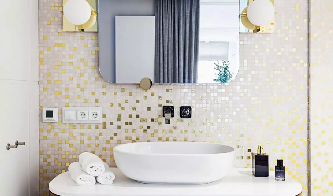 The bathroom is decorated with a golden mosaic