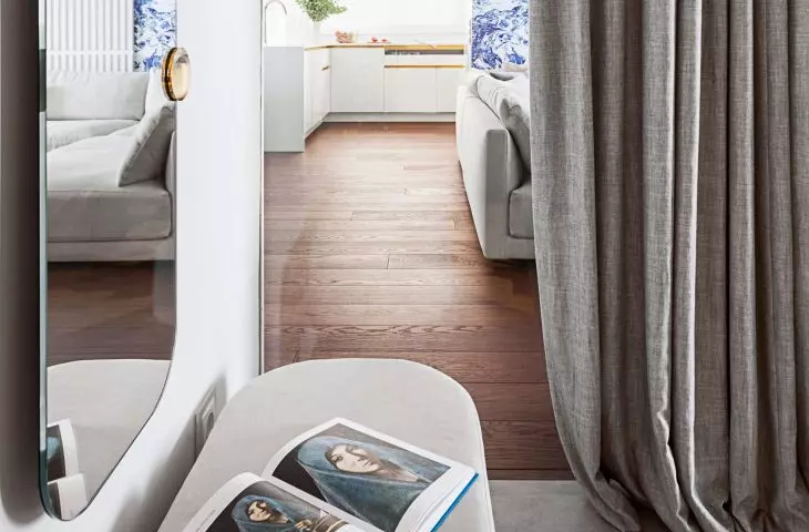 The bathroom has a glass window overlooking the living room