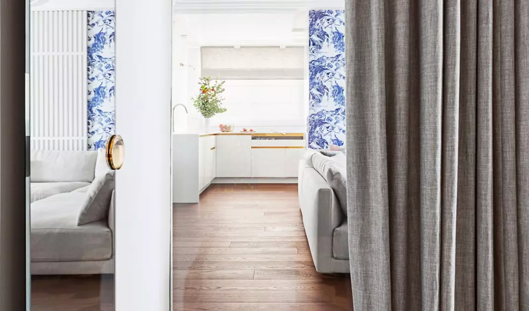 The bathroom has a glass window overlooking the living room