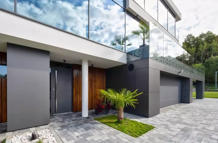 Aluminiowe drzwi CREO 311 HI Modern Graphite z naświetlem i doświetlem bocznym w duecie z bramą garażową UniTherm