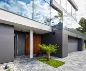Aluminiowe drzwi CREO 311 HI Modern Graphite z naświetlem i doświetlem bocznym w duecie z bramą garażową UniTherm