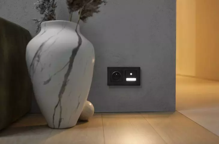 Lighting fixture with motion sensor and power socket (Simon 55 Line in matte black)