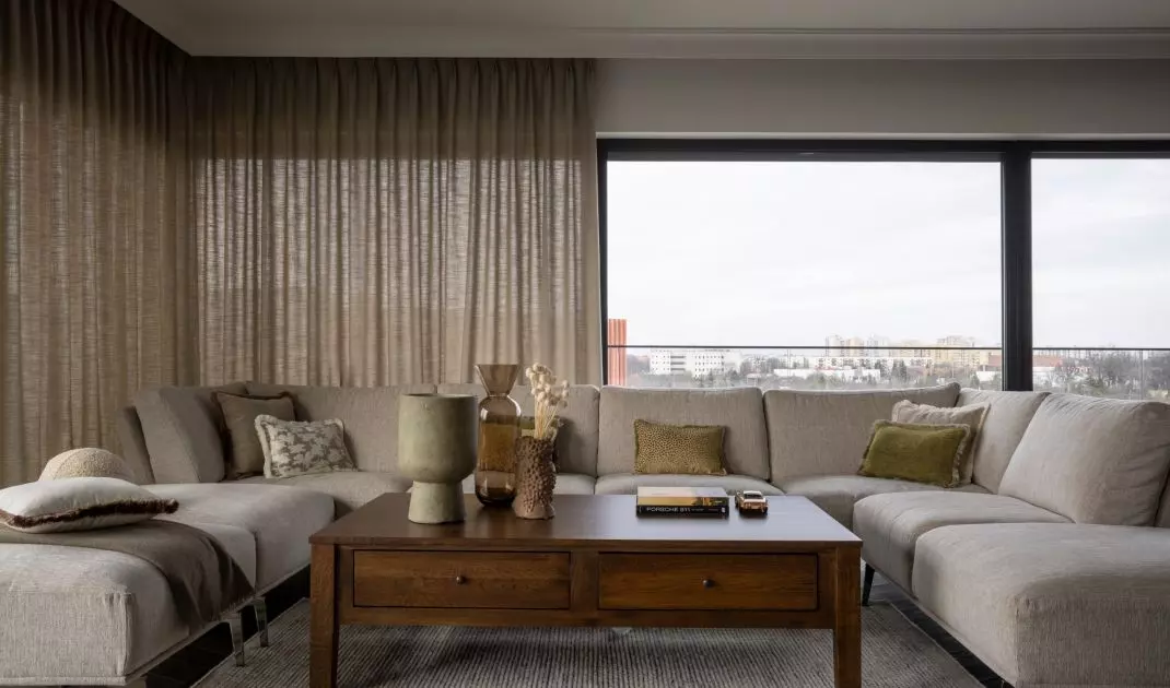 The living room has large glass windows on three sides