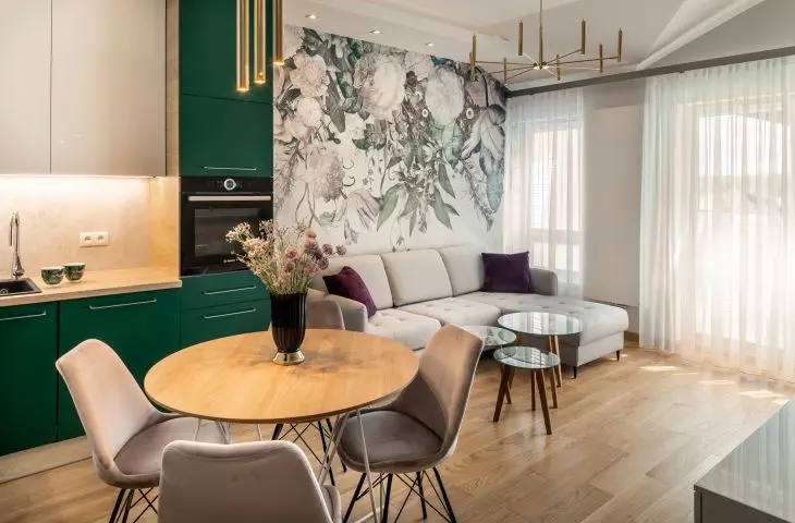 Green fronts of kitchen cabinets harmonize with wallpaper