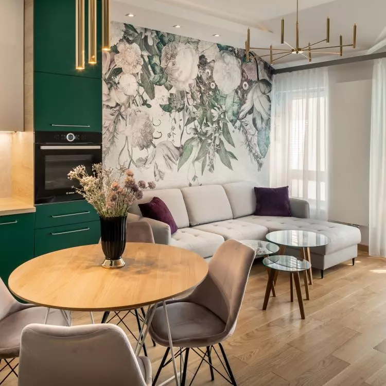Green fronts of kitchen cabinets harmonize with wallpaper