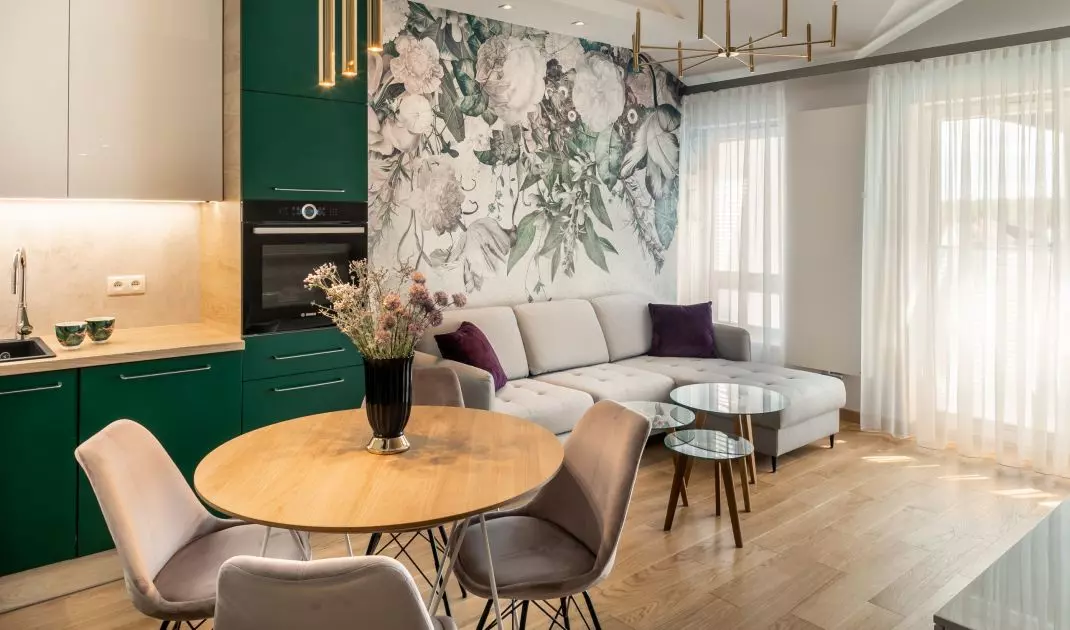 Green fronts of kitchen cabinets harmonize with wallpaper