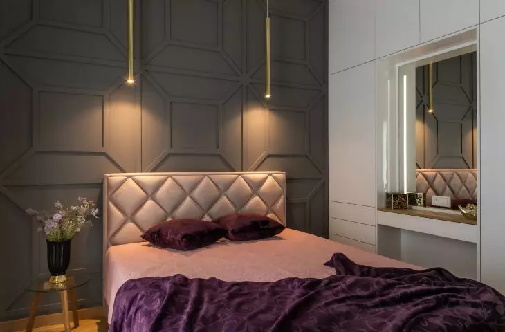 The wall behind the bed is decorated with striking stucco