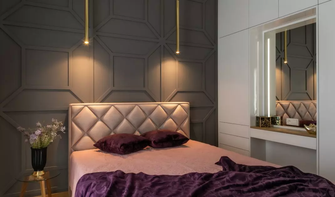 The wall behind the bed is decorated with striking stucco