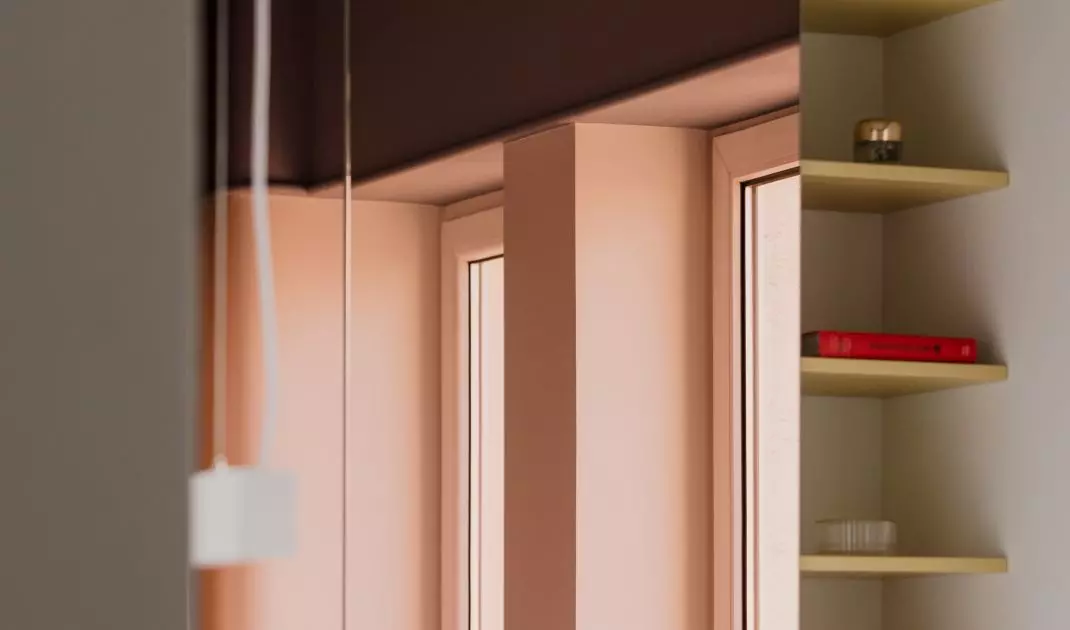 The upper cabinets in the kitchen were finished with a pink mirror
