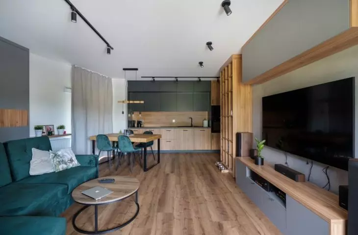 An arrangement combining natural wood, bottle green and raw loft-style accents