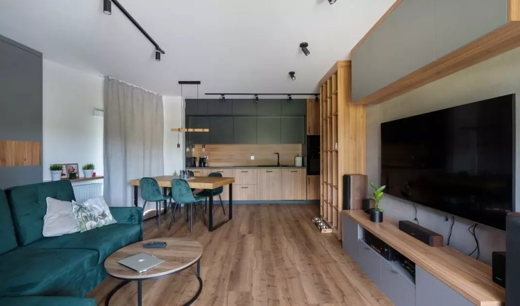 Aranżacja łącząca naturalne drewno, butelkową zieleń i surowe akcenty w stylu loft