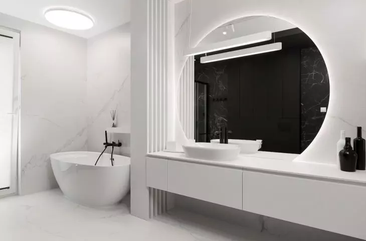 In the white part of the bathroom there is a bathtub 