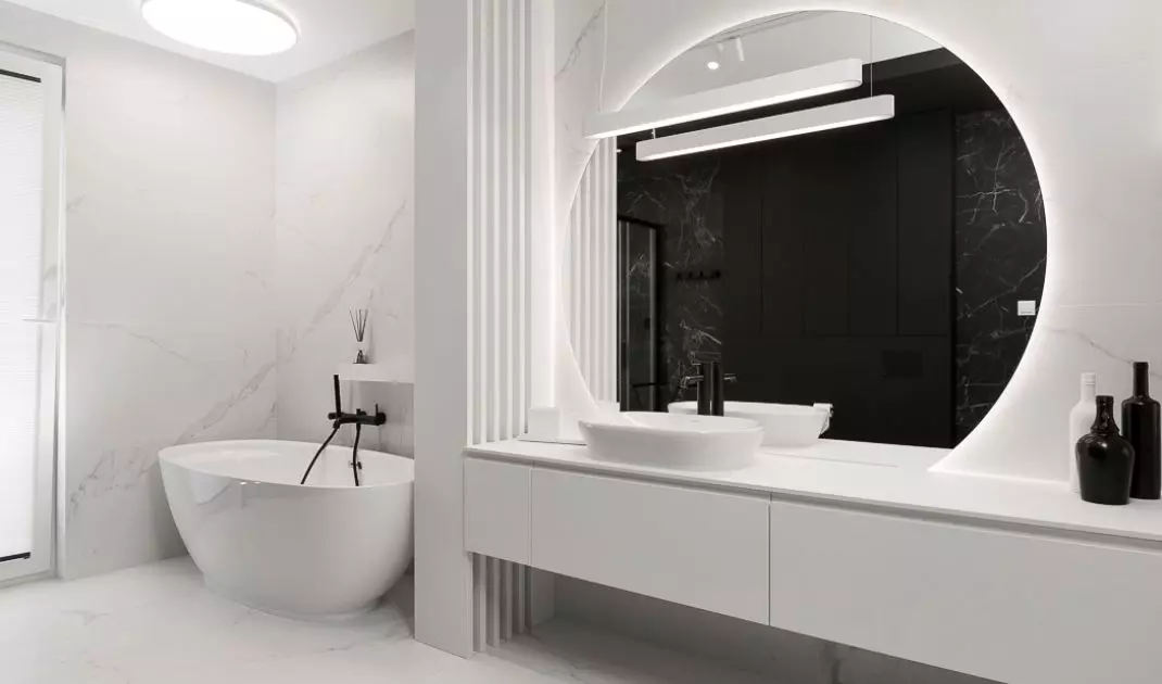 In the white part of the bathroom there is a bathtub 