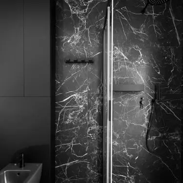 The black tiles feature striking white speckling