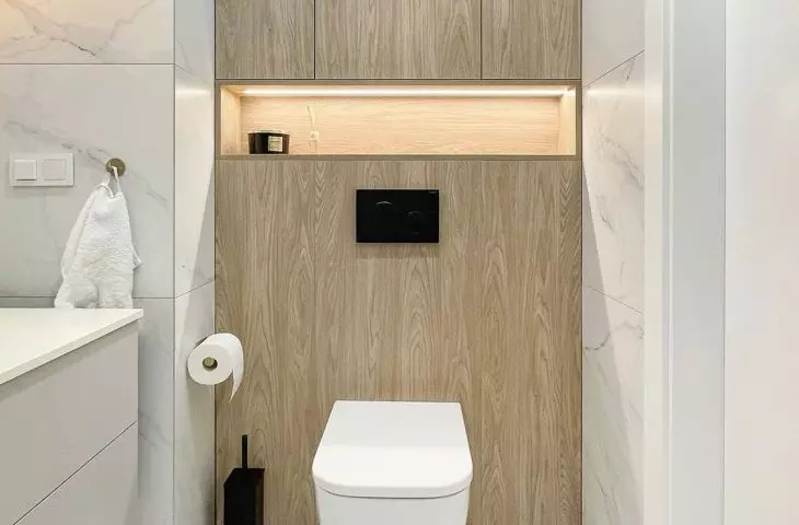 The built-ins above the toilet include an open illuminated shelf