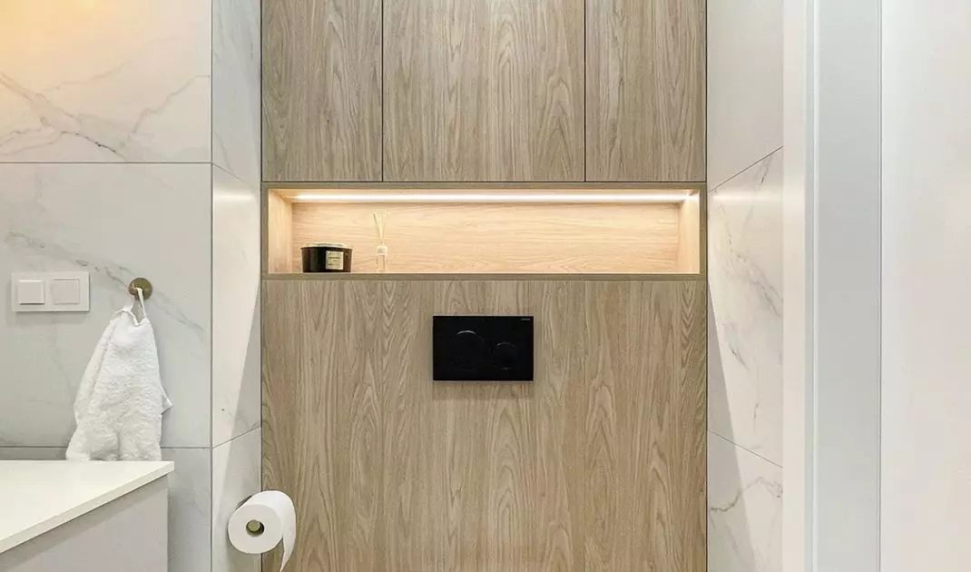 The built-ins above the toilet include an open illuminated shelf