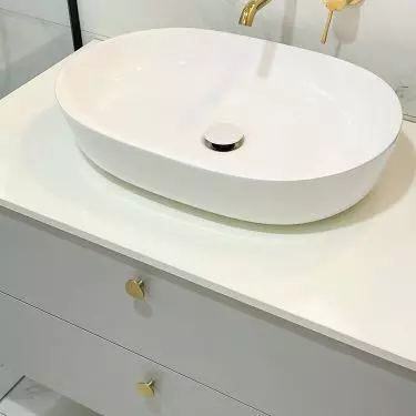 The white cabinet is decorated with gold handles  