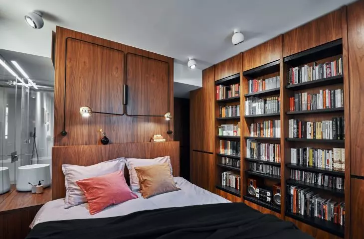 The bedroom is designed with plenty of space for books