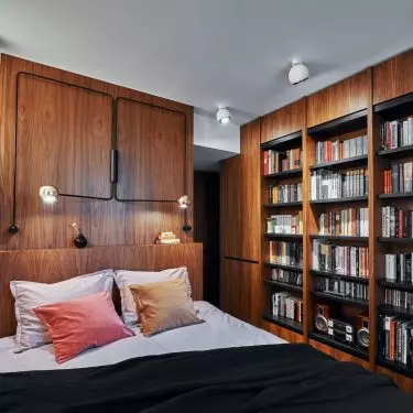 The bedroom is designed with plenty of space for books