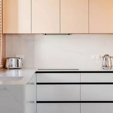 Salmon fronts create a subtle contrast with the rest of the kitchen