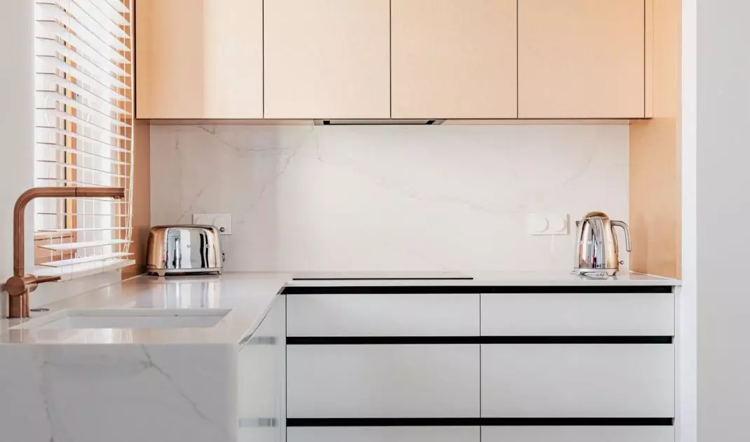 Salmon fronts create a subtle contrast with the rest of the kitchen
