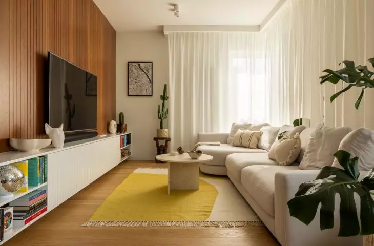 The living area has a wooden TV wall