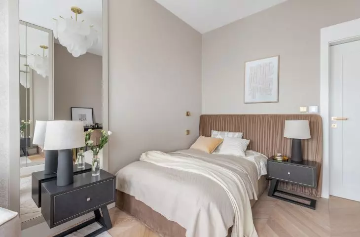 The bed is decorated with a headboard made of draped golden brown velour