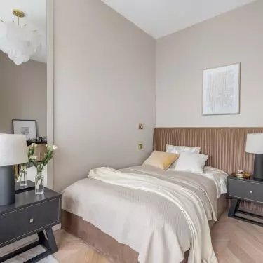 The bed is decorated with a headboard made of draped golden brown velour