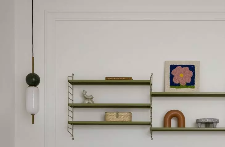 Next to the bed hangs a shelf, which is an ideal place to display trinkets