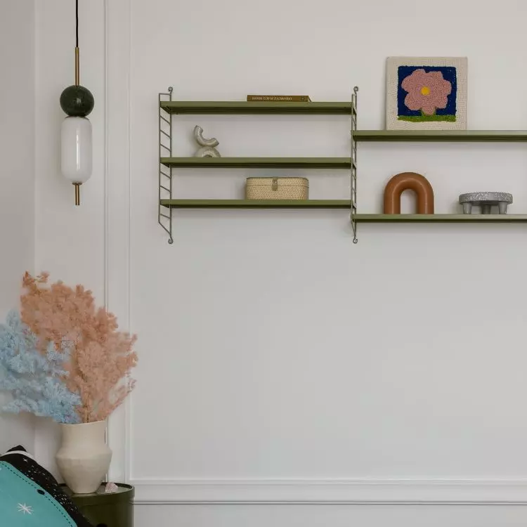Next to the bed hangs a shelf, which is an ideal place to display trinkets